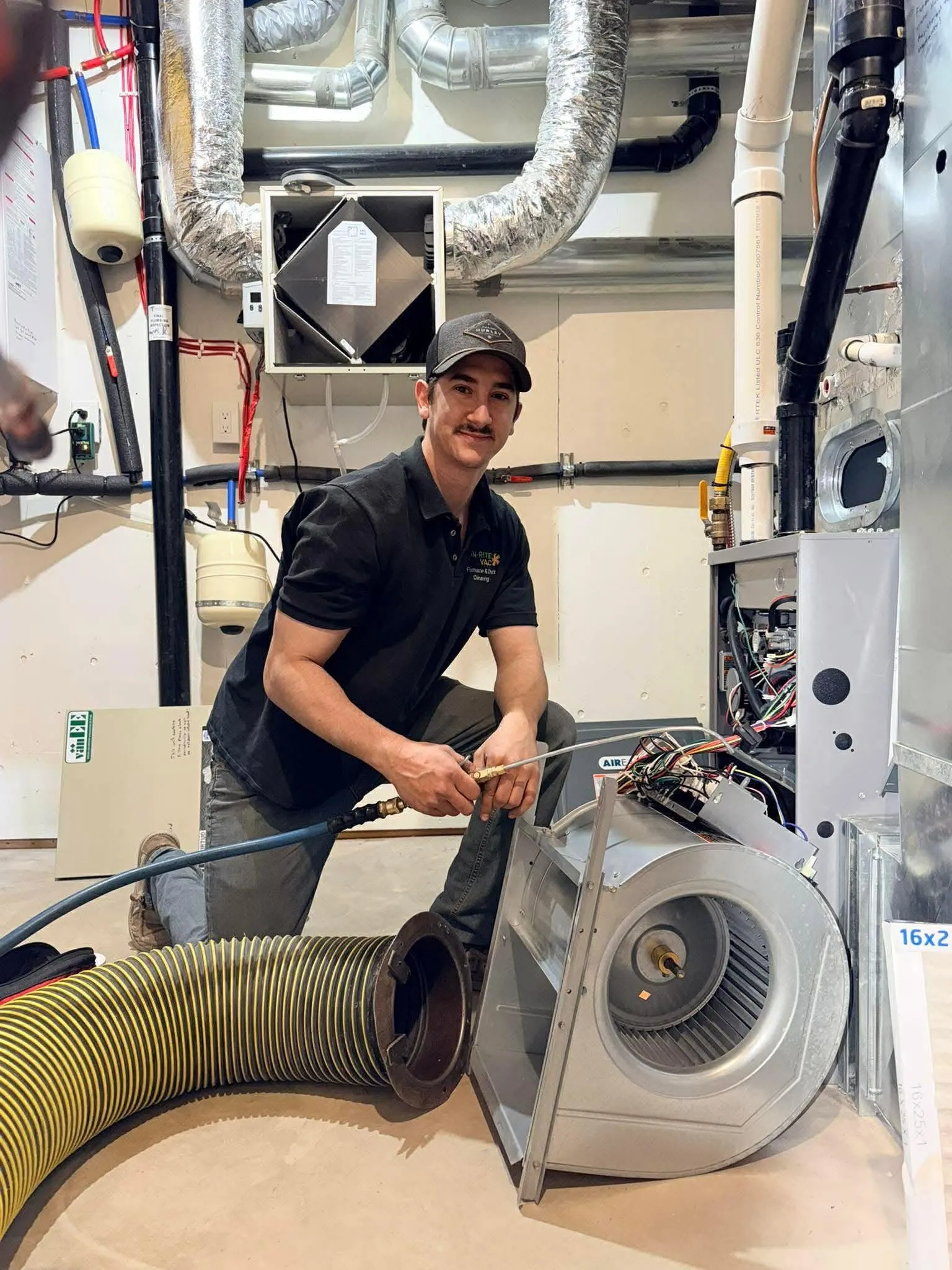 HVAC technician cleaning a furnace blower during professional duct cleaning service