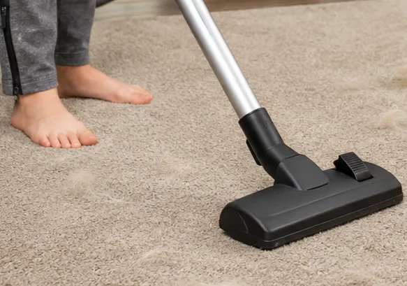 Close-up of a central vacuum floor brush attachment used during routine household cleaning.