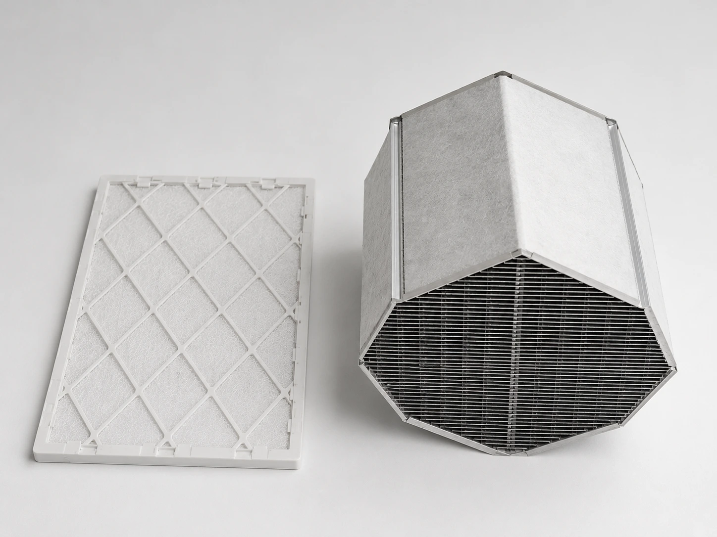 Clean HRV filter beside a removable heat recovery core, illustrating the two components most commonly cleaned during air exchanger maintenance.