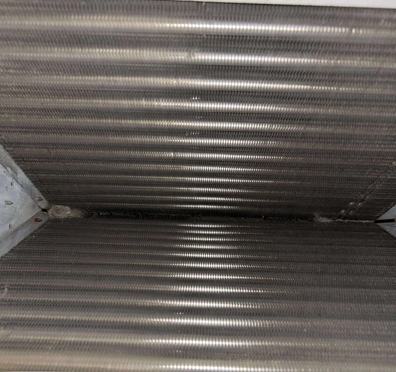 A/C coil fins after accessible dust and debris were cleaned